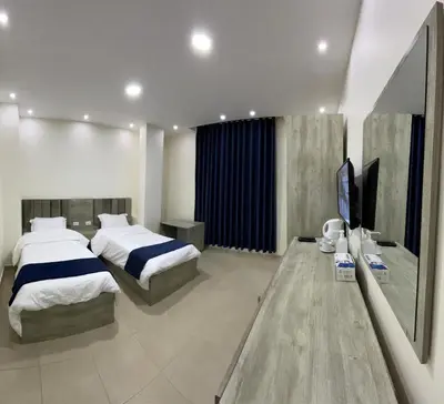 a bedroom with two beds and a flat screen tv at Petra Heaven Boutique in Wadi Musa
