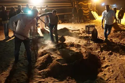 a group of men sheering a sheep in the dirt at Wadi Rum Backpacker Camp in Wadi Rum