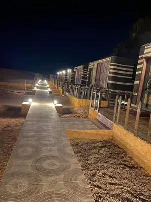 a row of lights on a beach at night at Enjoy Camp Bubble Luxury with Jeep Tour in Wadi Rum