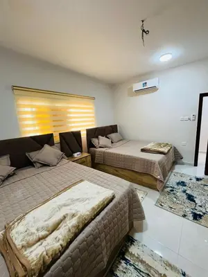 a bedroom with two beds and a couch at marram apartment in Aqaba