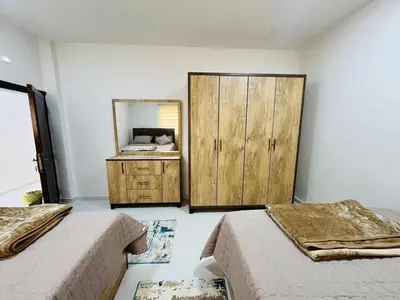 a bedroom with two beds and a mirror at marram apartment in Aqaba