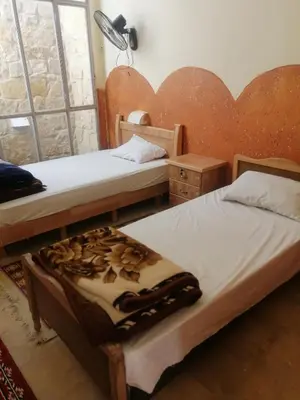 a bedroom with two beds and a lamp and a window at Dana star in Dana