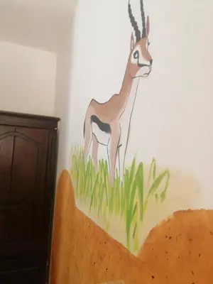 a painting of a gazelle on a wall at Dana star in Dana