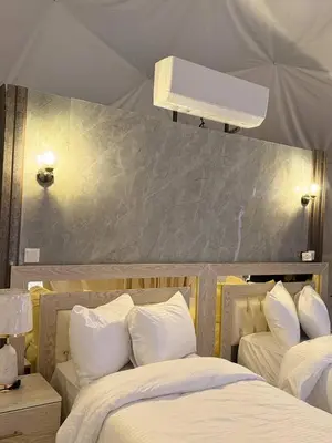 a bedroom with two beds with white pillows at Nada luxury camp in Wadi Rum