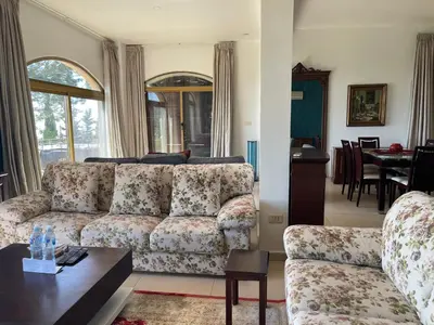 a living room with a couch and a table at Horizon 2 Cozy Villa in Amman