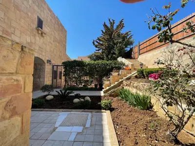 a garden with a stone building and a stone walkway at Horizon 2 Cozy Villa in Amman