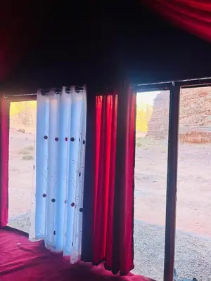 two windows with red and white curtains in a room at Moon City Luxury Tent in Wadi Rum
