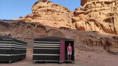 a man standing in a door in the desert at Moon City Luxury Tent in Wadi Rum