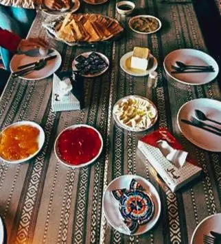 a table with plates and bowls of food on it at Faiesal Luxury camp & Tour in Wadi Rum