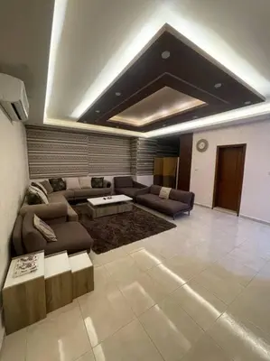 a living room with a couch and a table at شقة مفروشة in Rujm Maghghijhah