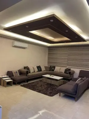 a living room with couches and a coffee table at شقة مفروشة in Rujm Maghghijhah