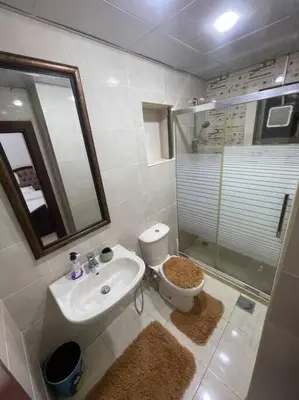 a bathroom with a sink and a toilet and a shower at شقة مفروشة in Rujm Maghghijhah