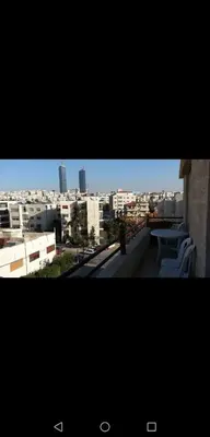 a view of a city skyline from a balcony at ستيديوهات مفروشة و مطلة في طابق ثالث و الرابع in Amman