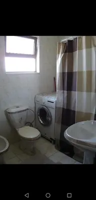 a bathroom with a toilet and a washing machine at ستيديوهات مفروشة و مطلة في طابق ثالث و الرابع in Amman