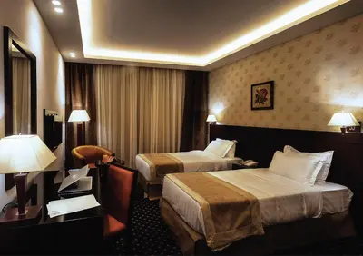 a hotel room with two beds and a chair at فندق سفن روزز in Amman
