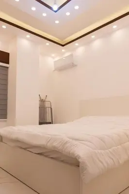 a white bedroom with a bed in a room at Prestige hotel apartment in Amman