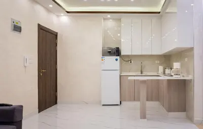 a kitchen with a white refrigerator and a counter at Prestige hotel apartment in Amman