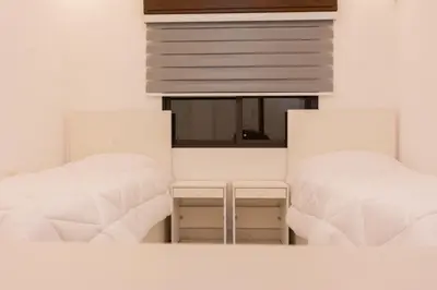 two beds in a room with a window at Prestige hotel apartment in Amman
