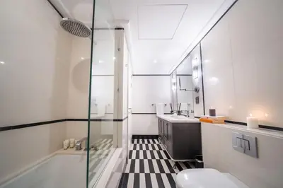 a bathroom with a shower and a sink and a toilet at Boulevard, Abdali Luxury 1 BR Apartment in Amman
