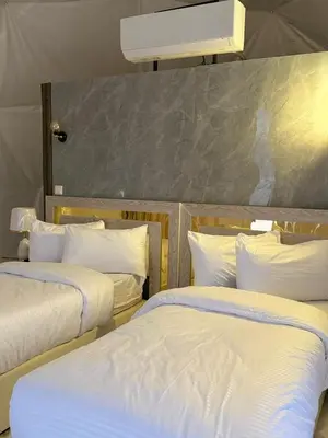 two beds in a room with white sheets and pillows at Rum Star Desert Camp in Wadi Rum