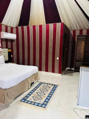 a bedroom with a bed and a rug on the floor at Rum Star Desert Camp in Wadi Rum