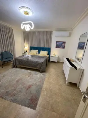 a bedroom with a bed and a couch and a table at Beautiful & Cozy Newly remodeled 2 Bedroom in Amman