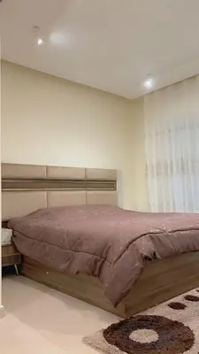 a bedroom with a large bed with avertisement at G Guest House in Amman