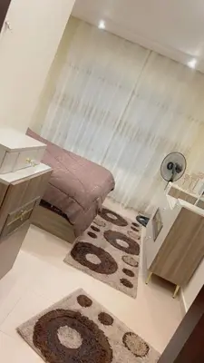 a small bedroom with a bed and a rug at G Guest House in Amman