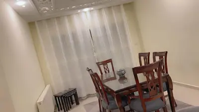 a dining room with a table and four chairs at G Guest House in Amman