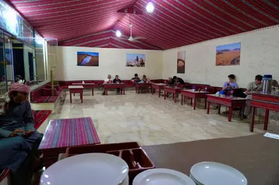 a group of people sitting at tables in a room at Wadi Rum Faris in Wadi Rum