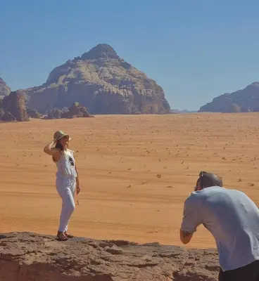 a man and a woman standing in the desert at Wadi Rum Faris in Wadi Rum
