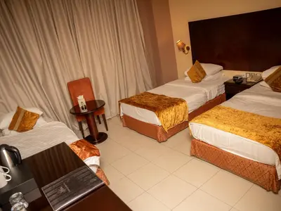 a hotel room with two beds and a table at JAZEERAT QUBTAN in Aqaba