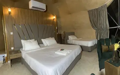a hotel room with two beds and a chair at 7stars in Disah