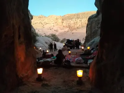 a group of people sitting in a cave with candles at family home Lodge in Dana