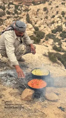 a man cooking food on top of a fire at family home Lodge in Dana