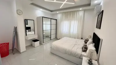 a white bedroom with a bed and a large window at شقة بغرفه نوم واحدة عمو سامي in Amman