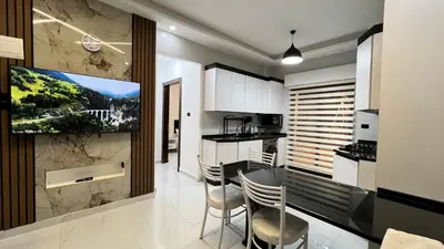 a kitchen with a table and chairs and a tv at شقق عمو سامي بغرفة نوم 1 in Amman