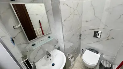 a white bathroom with a sink and a toilet at شقق عمو سامي بغرفة نوم 1 in Amman