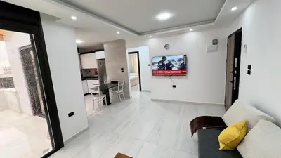 a living room with a couch and a tv on the wall at شقة رووف اطلاله رائعه عمو سامي 20 in Amman