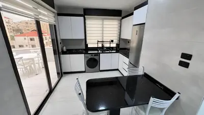 a kitchen with a table and chairs in a room at شقة رووف اطلاله رائعه عمو سامي 20 in Amman