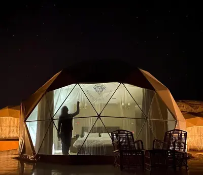 a man is standing inside of a tent at Bubble Emily camp in Wadi Rum
