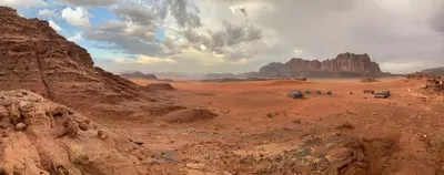 a group of people standing in a desert with mountains at Moon shine camp in Wadi Rum