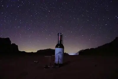 a bottle of wine and two glasses under the stars at Moon shine camp in Wadi Rum