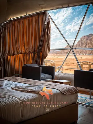 a bedroom with a bed and a view of the desert at RUM NEPTUNE lUXURY CAMP in Wadi Rum