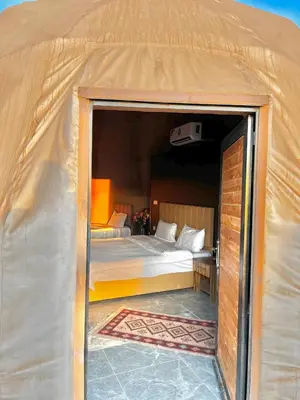 a large tent with a bed in a room at RUM NEPTUNE lUXURY CAMP in Wadi Rum