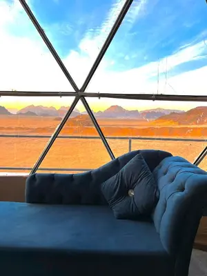 a couch sitting in front of a large window at RUM NEPTUNE lUXURY CAMP in Wadi Rum