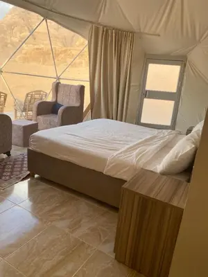a bedroom with a bed in a tent at Desert Elegance Luxury Bedouin Camp Panoramic View in Wadi Rum