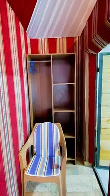 a room with a chair and a book shelf at Romantic Moment Rum CAMP in Wadi Rum