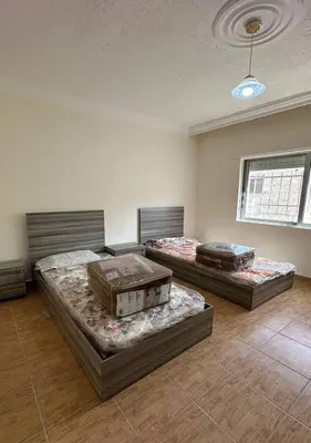 a room with three beds in a room at Tlaa al ali amman 3 rooms furnished apartment المحكمة الدستورية in Umm Uthainah