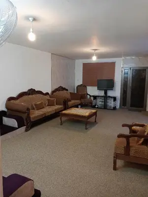 a living room with a couch and a tv at Bait al salam in Um Qeis